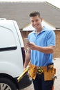 Builder With Van Checks Text Messages On Mobile Phone Outside Ho Royalty Free Stock Photo