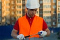 Builder vest and helmet construction site holding brick and hammer in hands Royalty Free Stock Photo