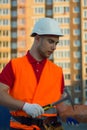 Builder vest and helmet construction site holding brick and hammer in hands Royalty Free Stock Photo