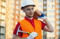 Builder vest and helmet construction site holding brick and hammer in hands Royalty Free Stock Photo