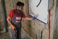 Builder wearing protective gloves and glasses, holding a hammer Royalty Free Stock Photo