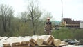 Builder wearing uniform and protective helmet standing and looking at the moving hook of the crane at the construction