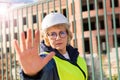 Builder woman on construction site in green vest and white helmet with tablet Royalty Free Stock Photo