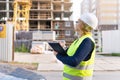 A woman Builder at a construction site inspects a house made of brick Royalty Free Stock Photo