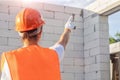 A builder woman in a helmet shows and manages construction work