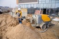 Builder in work clothes prepares tools and materials