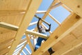 Builder at work with wooden roof construction. Royalty Free Stock Photo