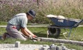 Builder worker arranging the granite cobblestone sett , paving decorative pedestrian pathway in the garden park