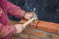 Builder worker with bricklayer hammer laying solid clay brick Royalty Free Stock Photo