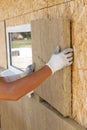 Builder worker installing insulation material on a wall. Royalty Free Stock Photo