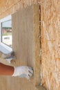 Builder worker installing insulation material on a wall. Royalty Free Stock Photo