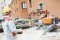 Builder worker operating demolition machine