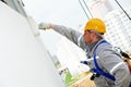 Builder worker painting facade of building with roller Royalty Free Stock Photo