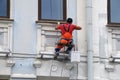 Builder worker painting facade of high-rise building Royalty Free Stock Photo