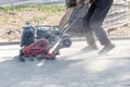Builder worker at sand ground compaction with vibration plate compactor machine before pavement roadwork. Royalty Free Stock Photo