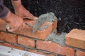 Builder worker with trowel building brick wall