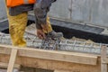 Builder worker tying a spacer to a rebar