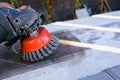 The builder works with an angle grinder. Wire cleaning brush. Cleaning metal embedded from rust and concrete