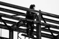 The Builder works at sunsetblack and white photo of a masked welder working at height