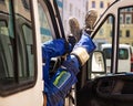 builder legs in blue pants and work shoes on the door of a small truck on a sunny day Royalty Free Stock Photo