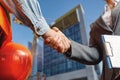 Builders and a businessman shake hands