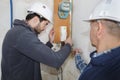 Builders checking electrical panel indoors Royalty Free Stock Photo