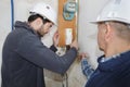 Builders checking electrical panel indoors