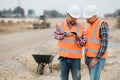 builders checking road construction plan on the phone