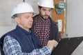 builders with clipboard and electrical panel indoors Royalty Free Stock Photo