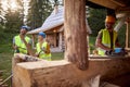 Builders are in a good mood while working at the cottage construction site in the forest. Workers, construction, nature Royalty Free Stock Photo