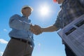 Builders Handshake, Architect And Contractor Agreement During Meeting Discussing Blueprint Buiding Plan On Construction