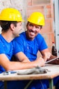 Builders having break on construction site Royalty Free Stock Photo