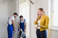 Builders are renovating a room, a woman speaks on the phone