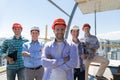 Builders Team Leader Over Group Of Apprentices At Construction Site, Happy Smiling Engineers Teamwork Concept