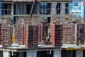 Builders are working on a construction site, assembling the frame of a high-rise building