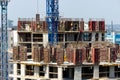 Builders are working on a construction site, assembling the frame of a high-rise building from rebar, cement blocks and others