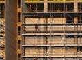 Builders working on scaffolding and platforms on different floors of a large modern construction site