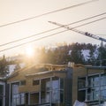 Building against mountain and crane at sunset