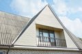 Building attic house construction with asbestos roof, cozy balcony and siding facade