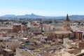 Building and Bell Tower of the Church of Santa Maria in the center of the town with mountains in the background. Royalty Free Stock Photo