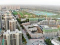 Aerial view of massive identical buildings site in construction with tower crane.