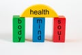 Building blocks in green, blue and red form a column portal with the following terms: body, mind, soul. The columns are connected Royalty Free Stock Photo