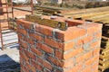 Building brick chimney in unfinished house construction roof. Bricklaying chimney. Royalty Free Stock Photo