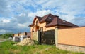 Building brick house construction with metal roof tiles, attic skylights, balcony