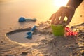 Building castle on beach with toy in sunset Royalty Free Stock Photo