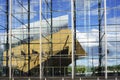 The building of Central Library Oodi in Helsinki is reflected in the glass facade of the neighboring Sanamotalo