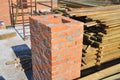 Building chimney from red bricks in unfinished house construction site. Chimney stack construction