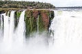 Building on a cliff over waterfall. Winter view of Iguazu Falls Devil's Throat under heavy clouds lead sky. Argentina.