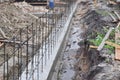 Building a concrete foundation for a new house with transverse reinforcement using iron bars, beams