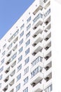 Building construction and architecture. The facade of a new high-rise bright house with balconies and windows against a blue sky Royalty Free Stock Photo